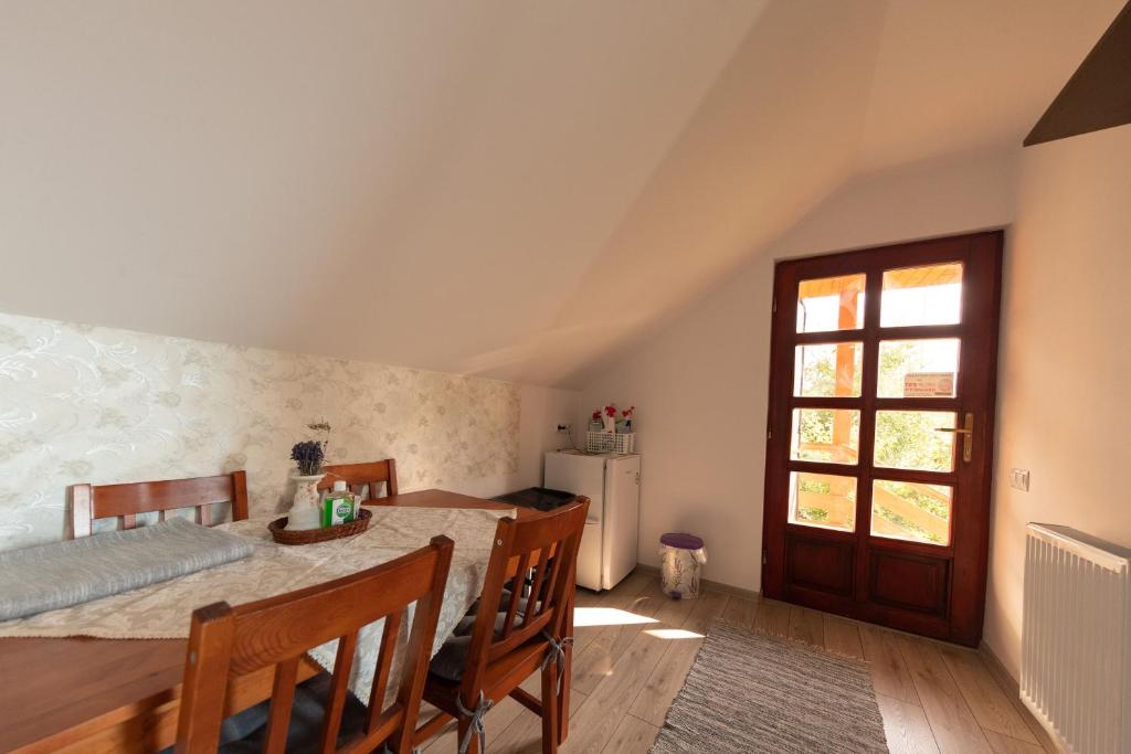 comedor con mesa, sillas y ventana en Csíkcsicsó, 699 Sillok utca, en Ciceu