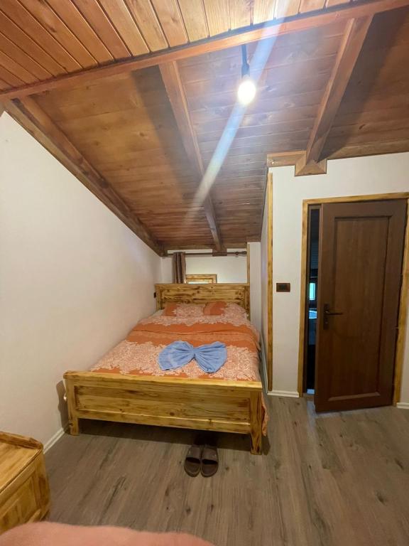 a bedroom with a bed in a room with wooden ceilings at natyra balcony in Valbonë