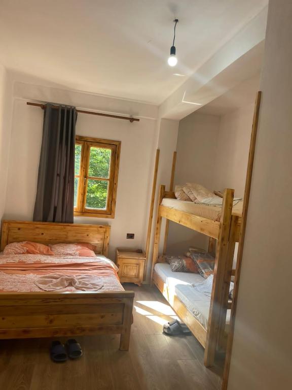 a bedroom with two bunk beds and a window at natyra balcony in Valbonë