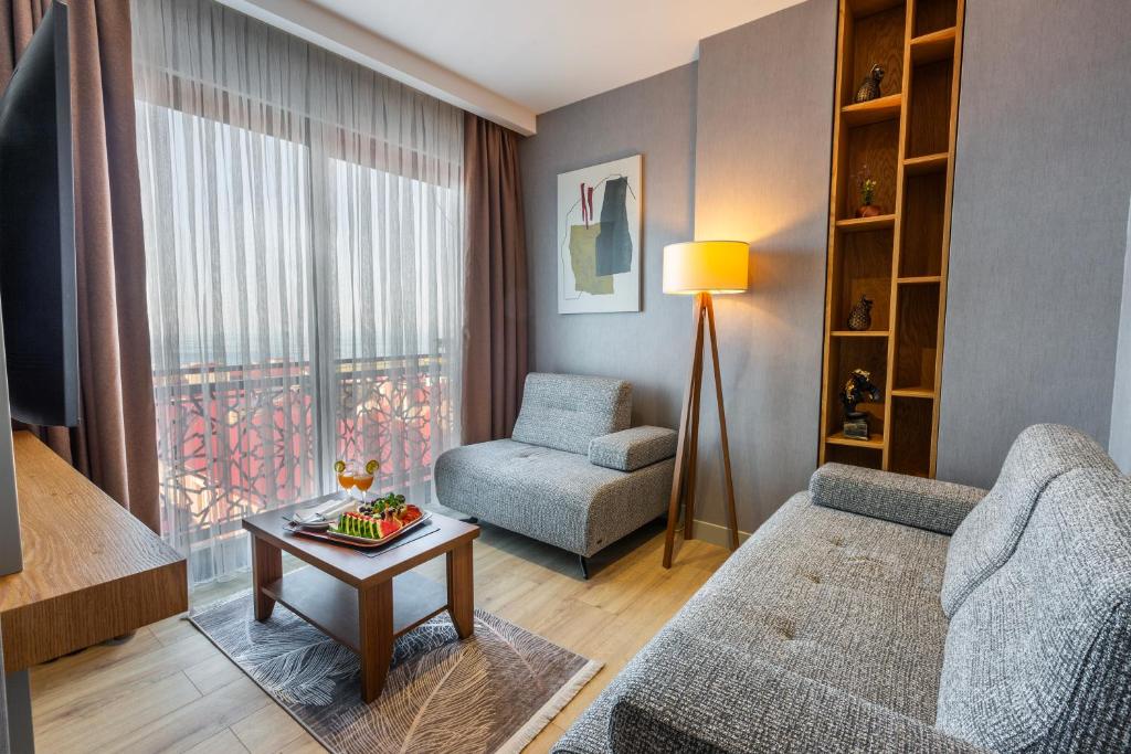 Una sala de estar con un sofá, una silla y una mesa. en North Star Hotel, en Trabzon