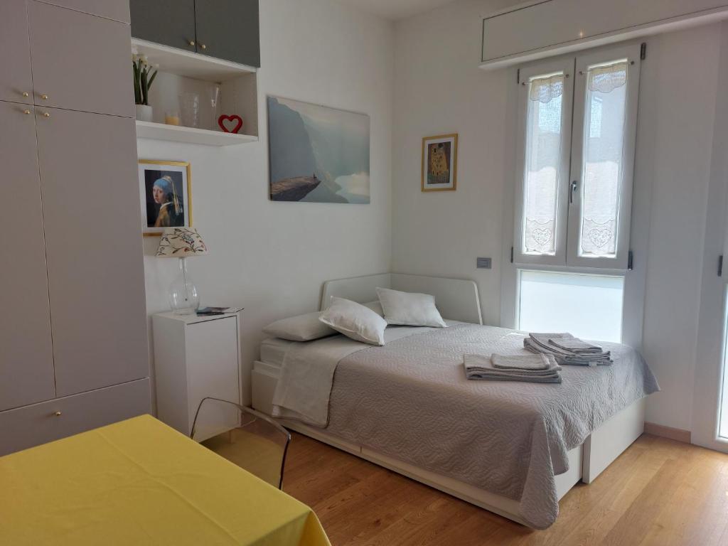 a white bedroom with a bed and a window at A UN PASSO DALL'OSPEDALE in Padova