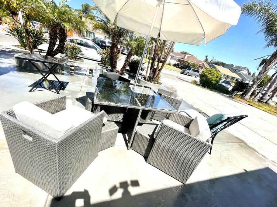 een tafel en stoelen met een parasol op een patio bij STUDIO-Beach-LAX SPC-X- EL-SEGUNDO-AIR-FORCEBASE in Inglewood
