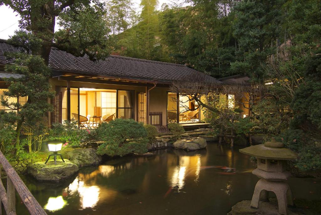 uma casa com um lago de carpas em frente em Gyokutei em Hakone