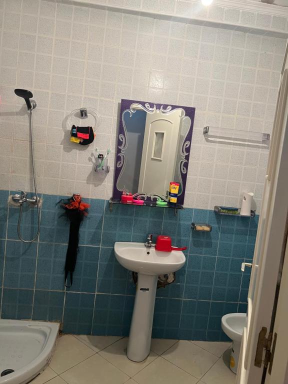 La salle de bains est pourvue d'un lavabo, d'un miroir et de toilettes. dans l'établissement مغوغة كبيرة طريق تطوان, à Tanger