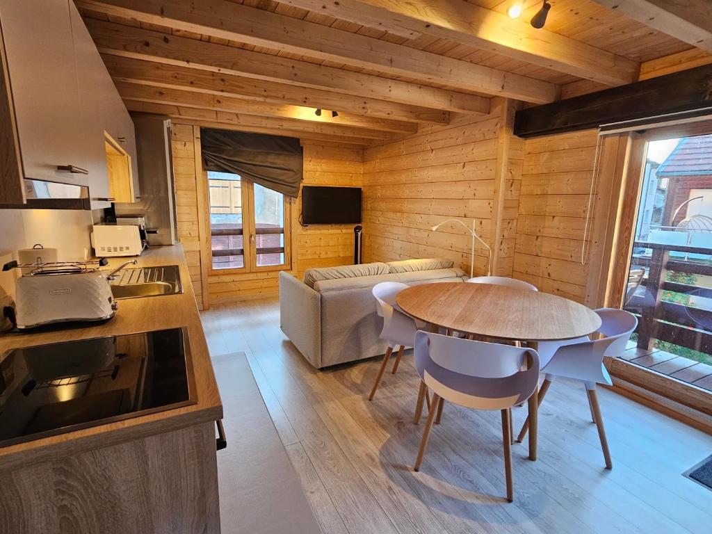 uma cozinha e sala de estar com uma mesa e um sofá em Cozy, quiet apartment in town center - near Geneva, Annecy, Chamonix, Lac Léman em Bons