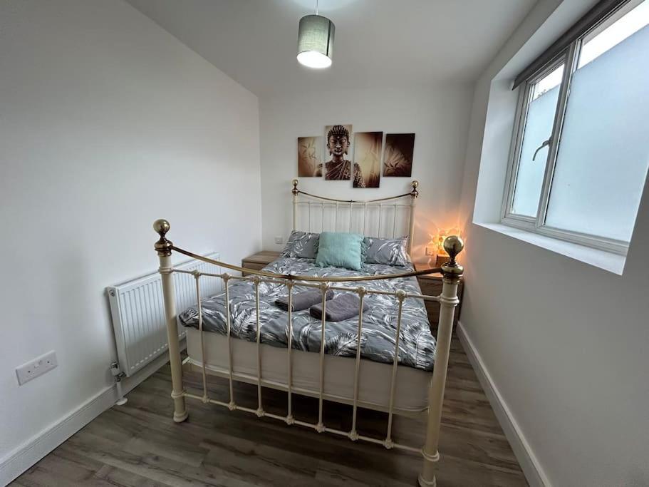 a bedroom with a bed in a room with a window at Bali Bliss Garden Flat with Parking in Enfield