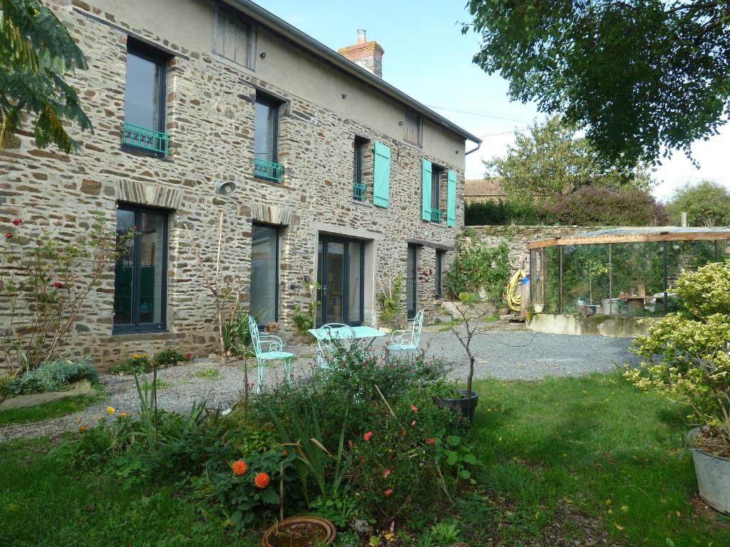 uma casa de pedra com um jardim em frente em L' ALBIZIA em Saint-Martin-de-Sallen