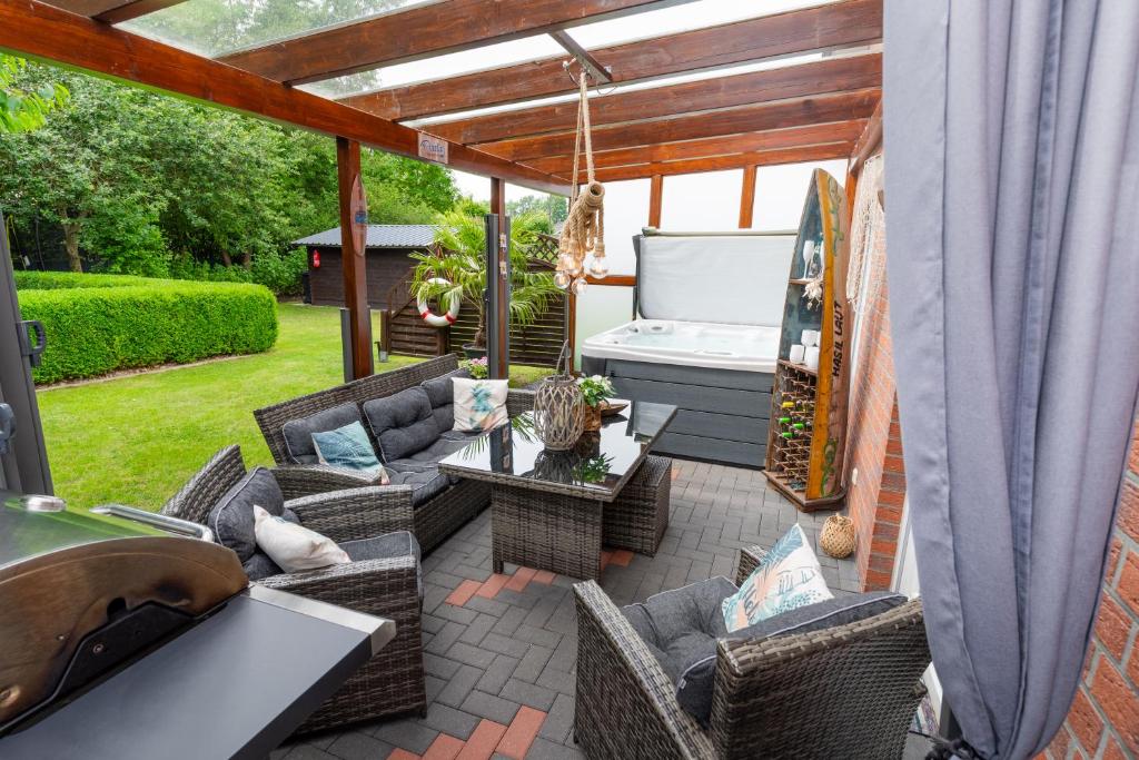 a patio with wicker furniture and a bed at Leeloo s Sunlight in Hodenhagen