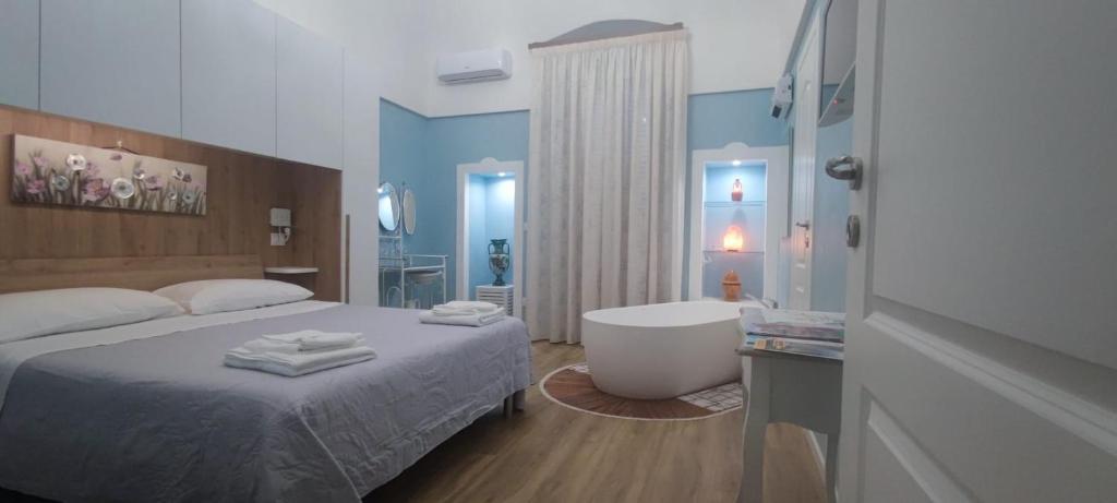 een slaapkamer met een bed en een bad en een badkamer bij Puglia Holiday Home in Mola di Bari