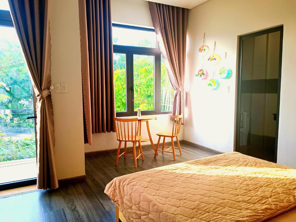 Schlafzimmer mit einem Bett, einem Tisch und einem Fenster in der Unterkunft MyTran Homestay-HauLoan in Quy Nhon