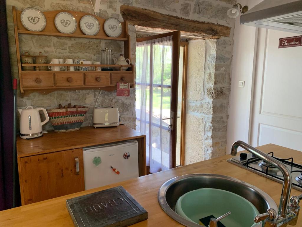 una cucina con lavandino e piano di lavoro di Coutillard a Parisot