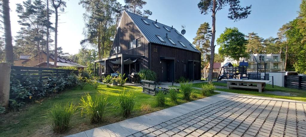 a black house with a gambrel roof at WAVEhouse Pobierowo in Pobierowo