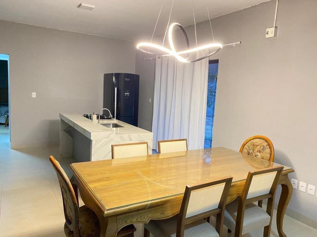 a dining room with a wooden table and chairs at Casa aconchegante 303 sul in Palmas