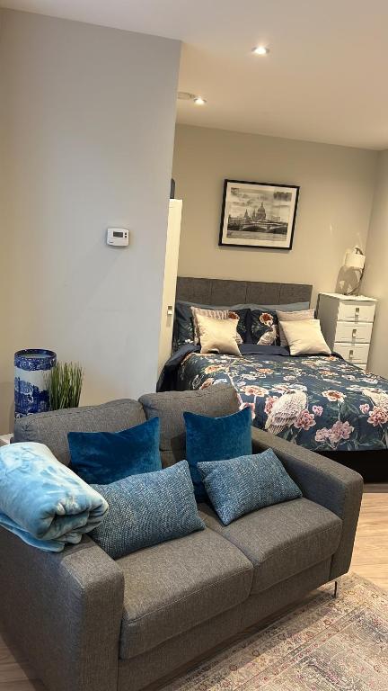 uma sala de estar com um sofá e uma cama em Sweet Swan House em Rickmansworth
