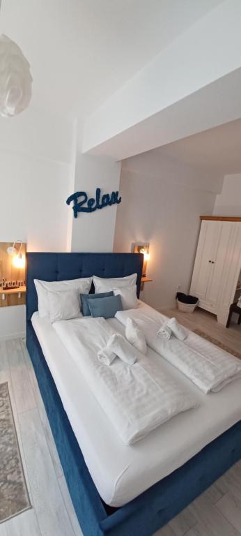 uma grande cama branca com lençóis e almofadas brancos em Angel apartament em Sibiu