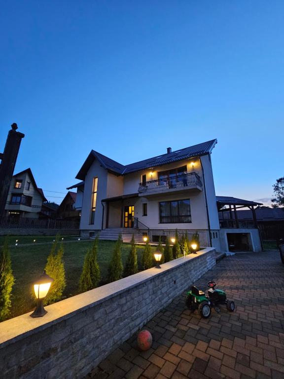 a house with a motorcycle parked in front of it at Casa Diecilor in Vatra Dornei