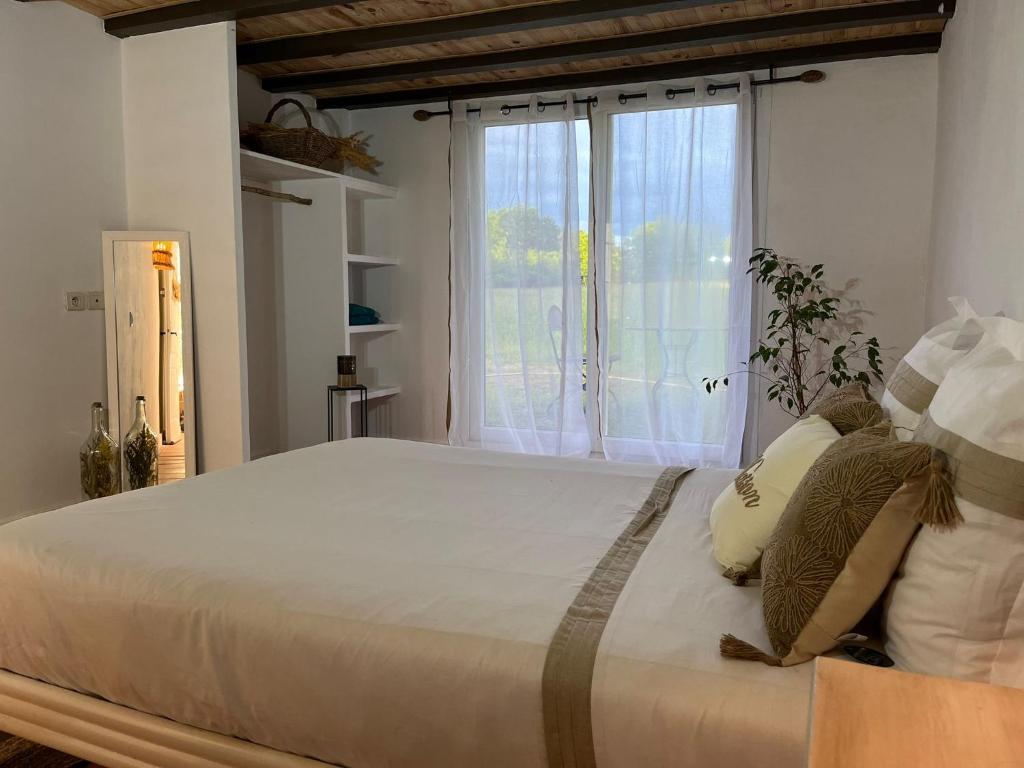 a bedroom with a large bed with a window at Domaine Royal Quercy in Monclar-de-Quercy