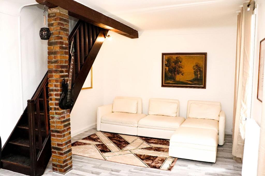 un soggiorno con 2 sedie bianche e un divano di chez Moon a Le Blanc-Mesnil