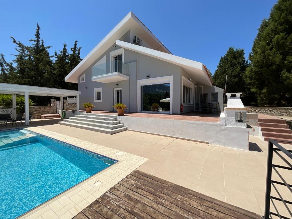 a villa with a swimming pool and a house at villa Aphrodite Maritsa in Pastida