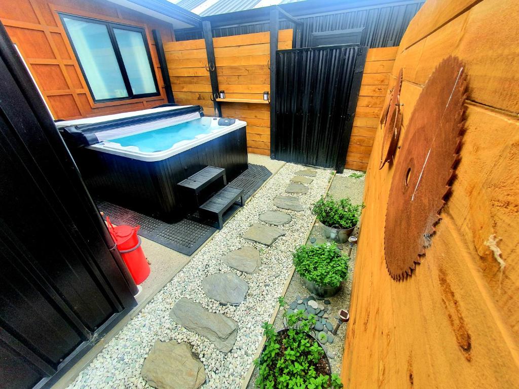 uma casa de banho com banheira e algumas plantas em Hawea Heaven: Superking beds + Hot Tub + Mountain em Wanaka