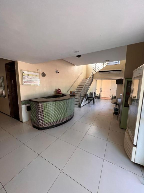 a hallway with a staircase in a building with white tiles at Hotel Peritoró in Peritoró