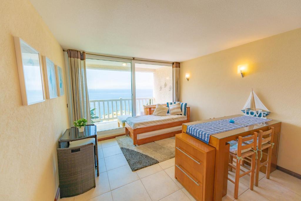 プチュンカビにあるOceana Suites Bahia Pelicanosのリビングルーム(ベッド付)が備わり、海の景色を望めます。