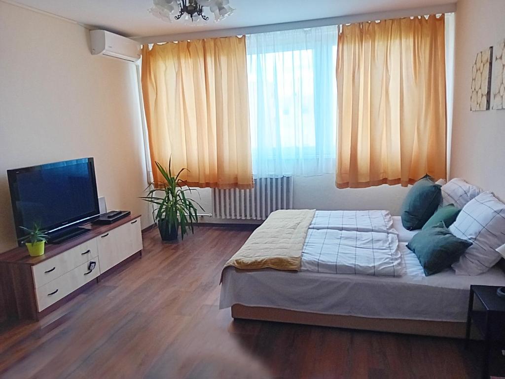 a bedroom with a bed and a flat screen tv at Green belt apartmann in Budapest