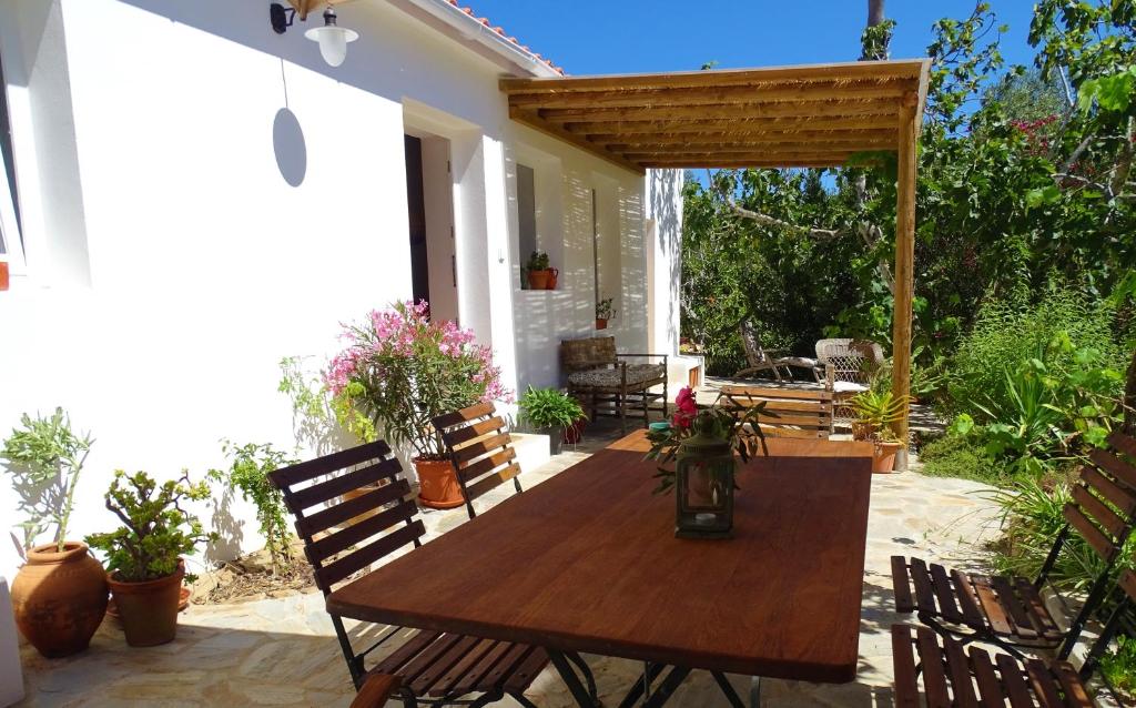 een patio met een houten tafel en stoelen bij Três Figos in São Luis