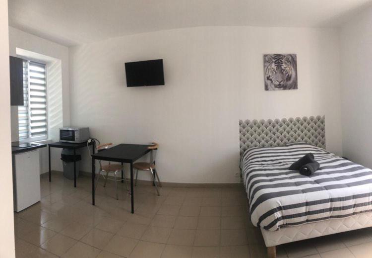 a bedroom with a bed and a table and a desk at Appart'Evry 1G in Évry-les-Châteaux