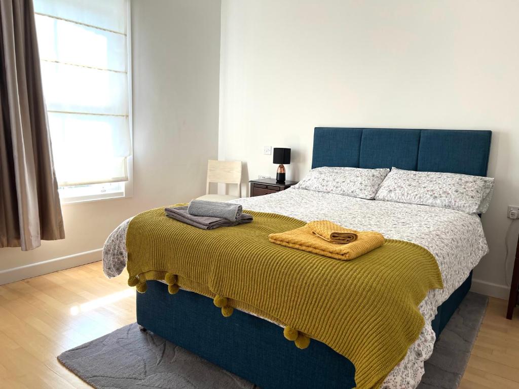 een slaapkamer met een bed met een gele deken erop bij 300m to Fitzwilliam museum 3 en-suites double bedroom Victoria house in Cambridge