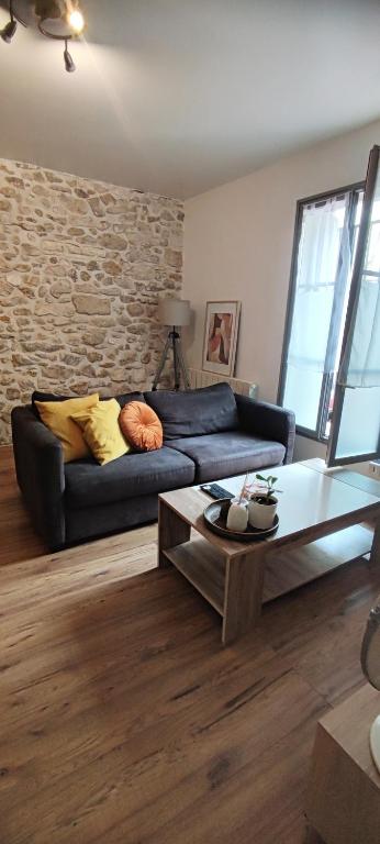 a living room with a blue couch and a stone wall at Montpellier centre-ville in Montpellier