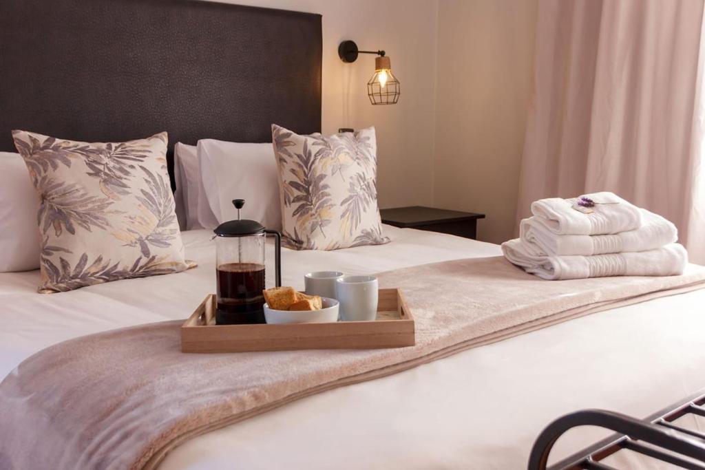 a bed with a tray of towels and a plate of food at Cradock Guest House in Cradock