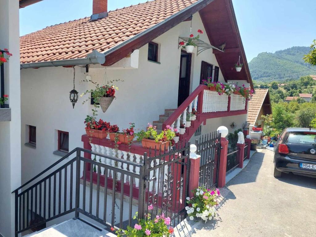 uma casa com flores nas escadas e uma cerca em Guesthouse Jelena em Višegrad