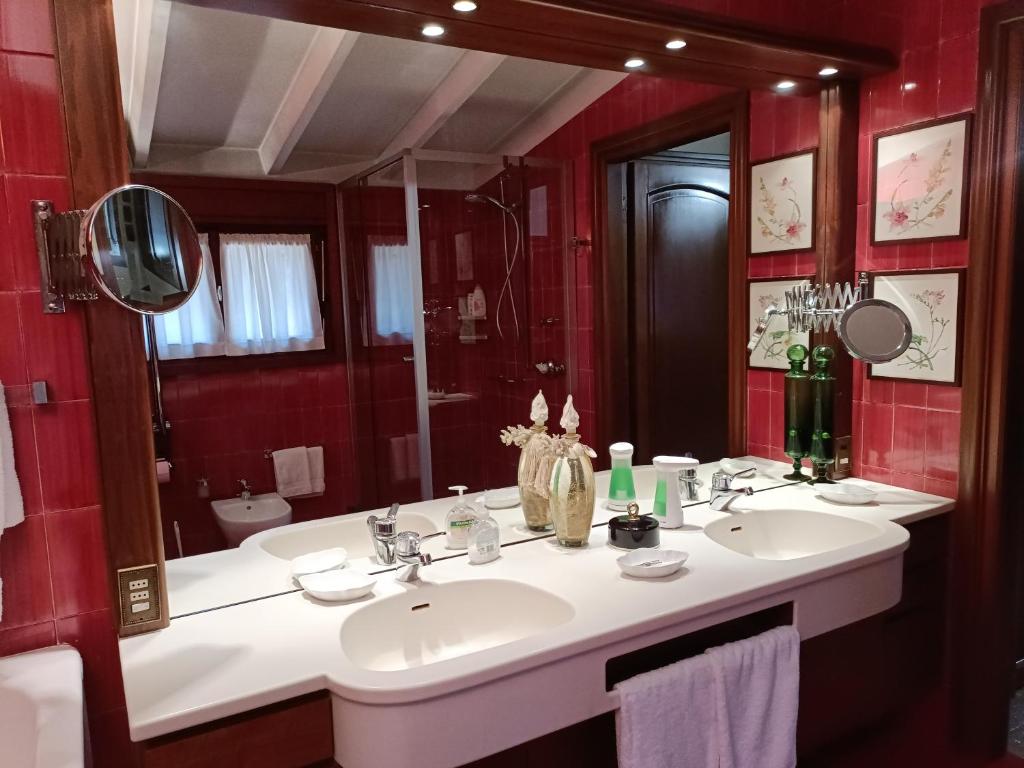 ein Badezimmer mit zwei Waschbecken und einem großen Spiegel in der Unterkunft Chez Queen B&B in Lurate Caccivio