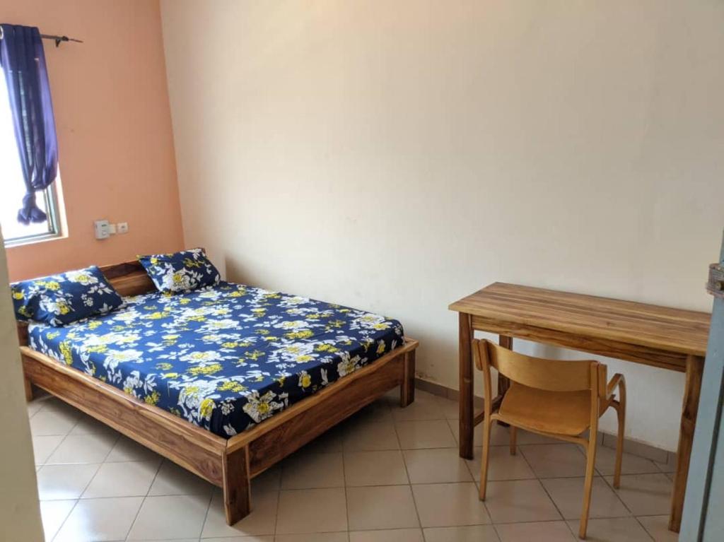 1 dormitorio con 1 cama, 1 mesa y 1 silla en BM Akwaba, en Palimé