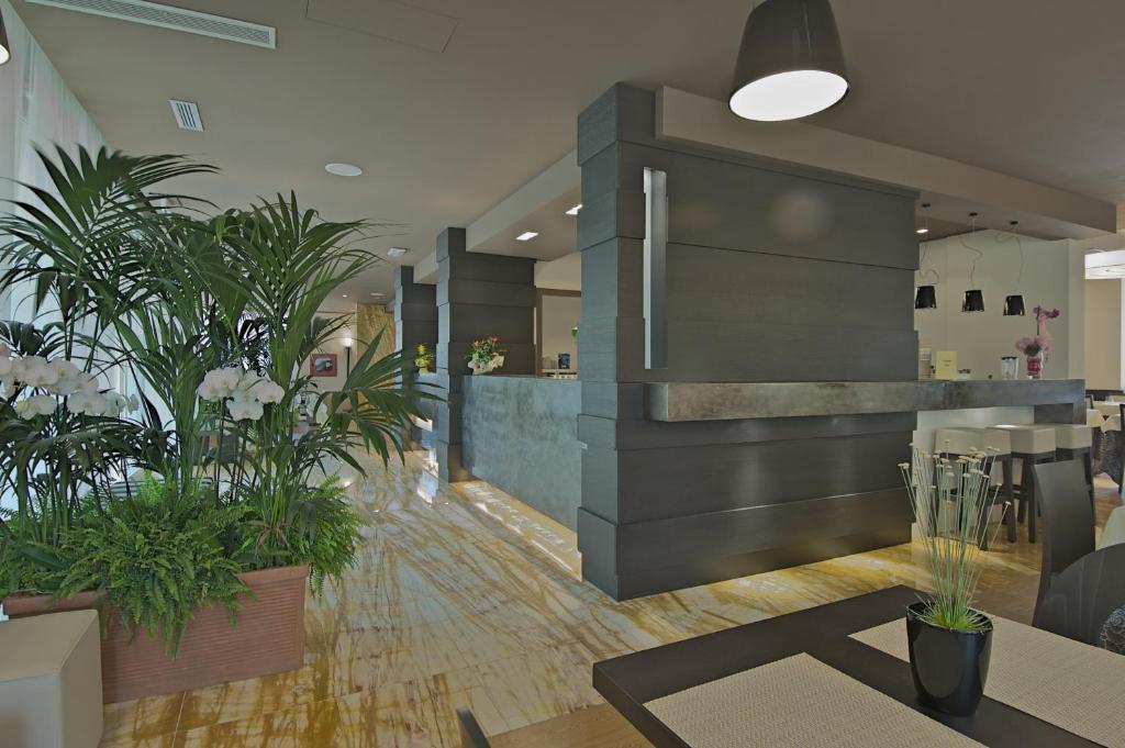 a lobby with potted plants in a building at Zen Hotel Versilia in Marina di Pietrasanta