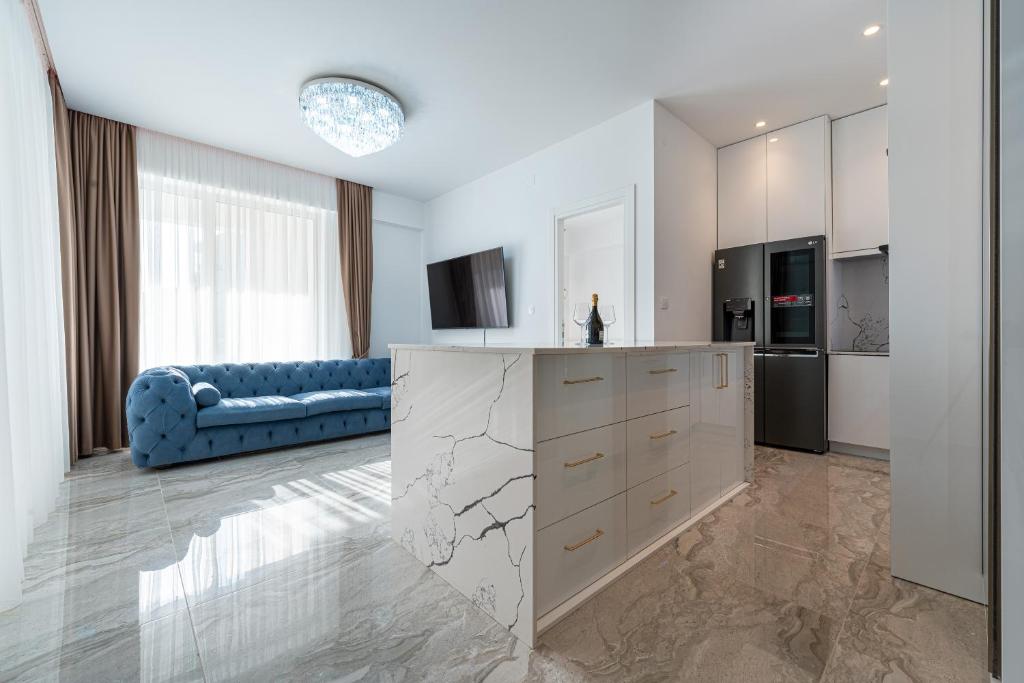 uma cozinha e sala de estar com um sofá azul em Altido Luxury Apartments em Budva