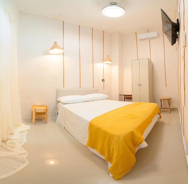 Hostal Mamamambo في سانتو دومينغو: غرفة نوم عليها سرير مع بطانية صفراء