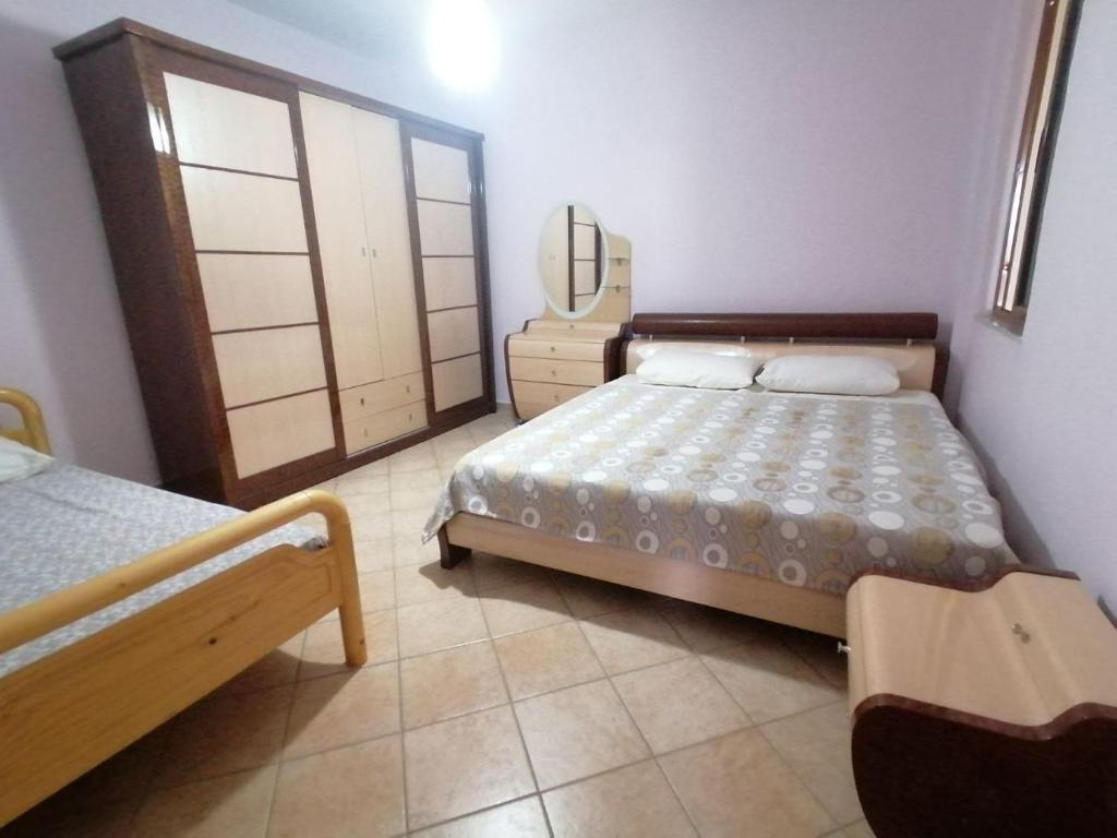 een slaapkamer met 2 bedden en een dressoir met een spiegel bij Big Apartment by the Adriatic Sea in Durrës