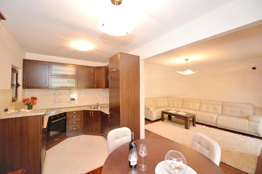 eine Küche und ein Wohnzimmer mit einem Tisch und einem Sofa in der Unterkunft Apartment Nikolija in Dobrota