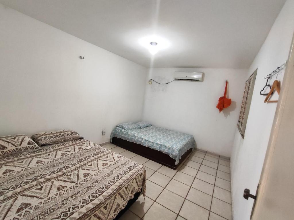 a small room with two beds and a small bench at Barreirinhas - Chalé Tubarão in Barreirinhas
