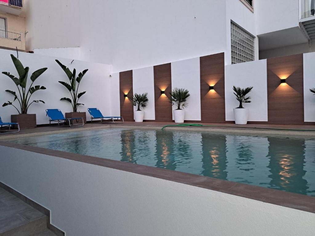 a swimming pool in a building with plants at Pátio C'un Casinhas in Nazaré