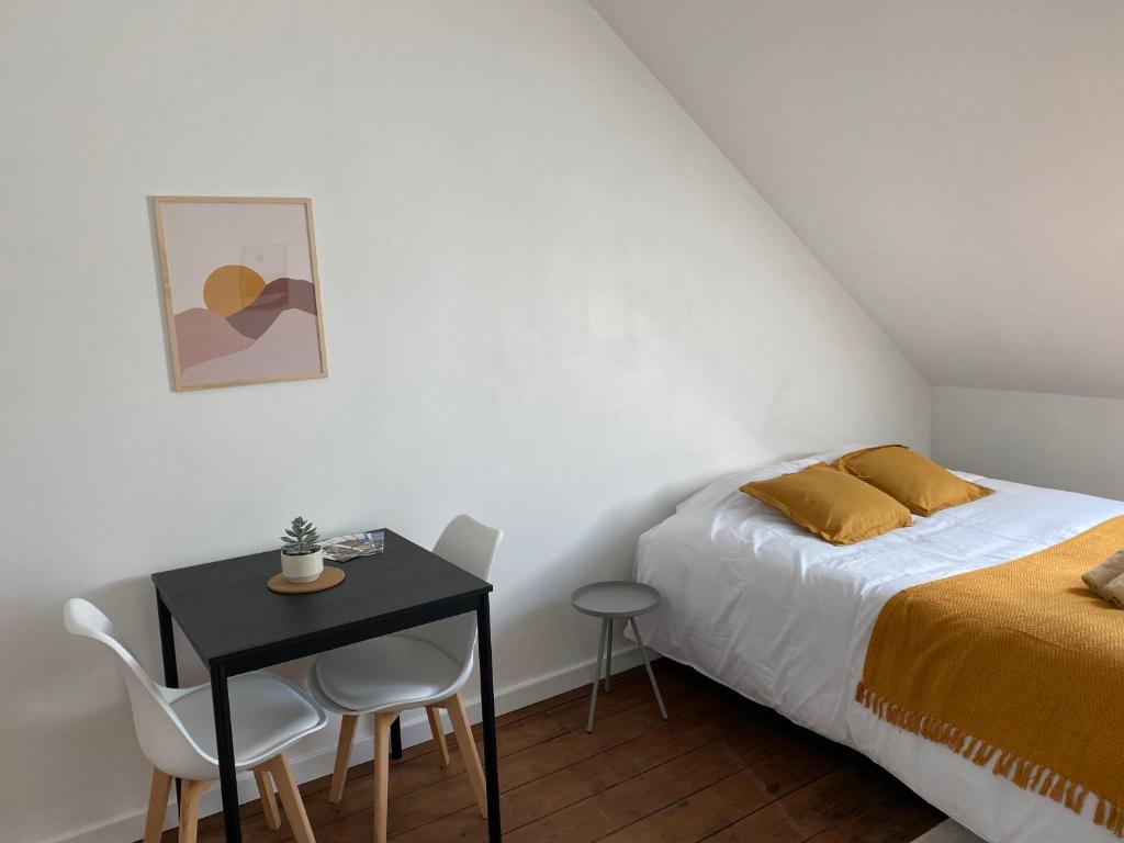 a bedroom with a bed and a table and chairs at Mimosa* Proche Centre-Ville et CHU*Parking in Amiens