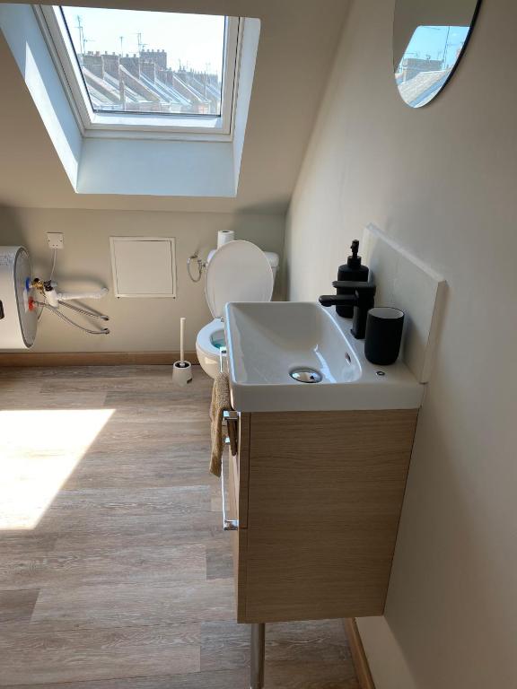 a bathroom with a sink and a toilet with a window at Mimosa* Proche Centre-Ville et CHU*Parking in Amiens