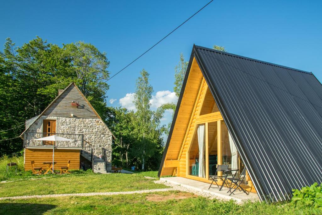 a house with a black roof and a barn at Mountain inn in Žabljak