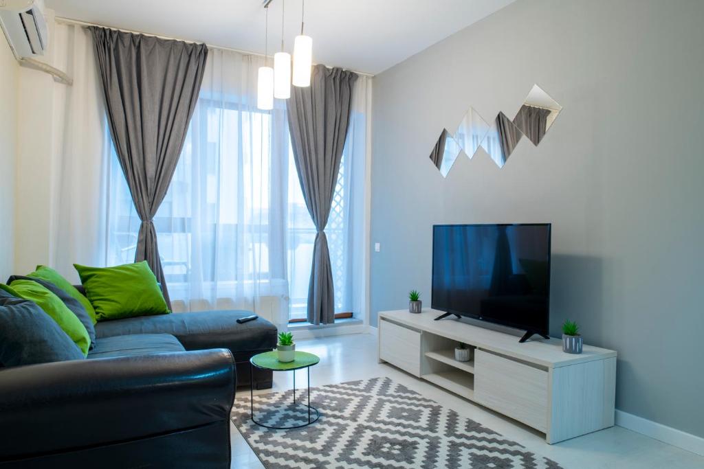 a living room with a couch and a tv at GviTown Central Apartment in Bucharest