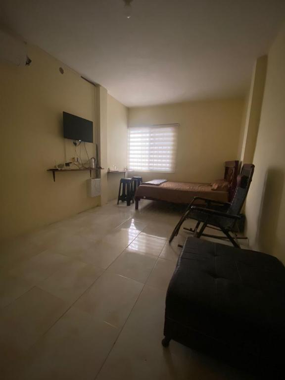 sala de estar con sofá y ventana en Blue House - Via a la costa en Guayaquil