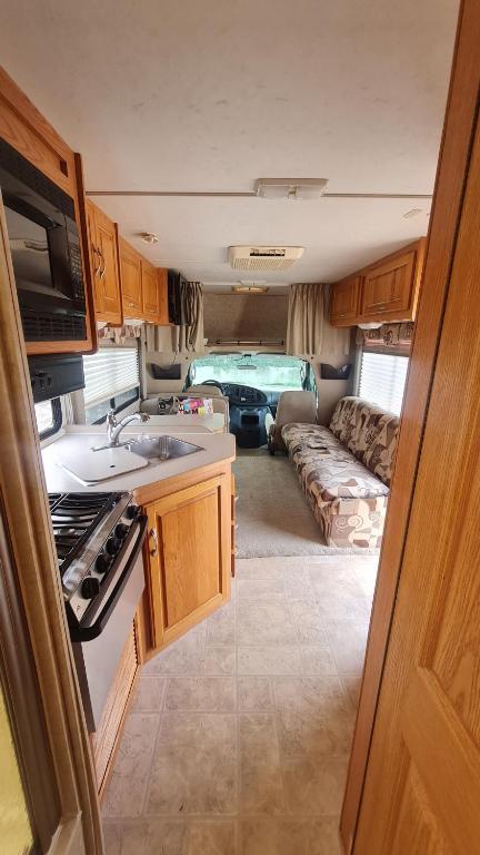 a kitchen and living room of an rv at Location atypique en camping car americain au bord du lac de Miélan, proche de Marciac in Miélan