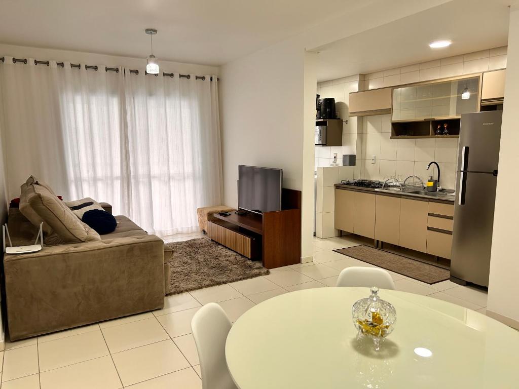 Apto amplo e confortável في تيجوكاس: غرفة معيشة مع أريكة وطاولة