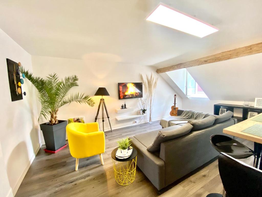 a living room with a couch and a yellow chair at Beau duplex à deux pas du port in Le Tréport